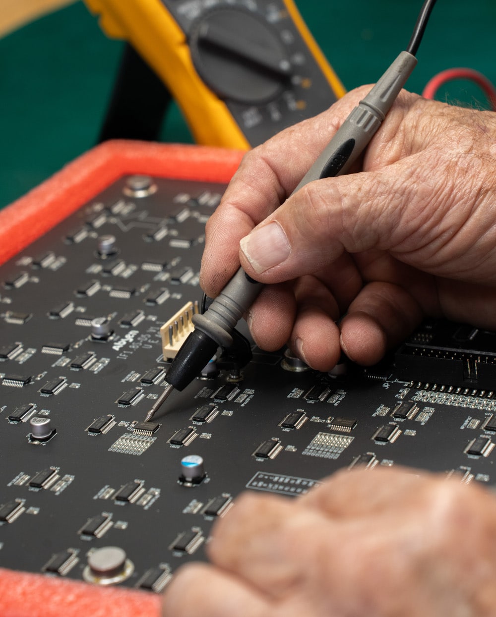 A technician performs circuit board repairs on an LED module.