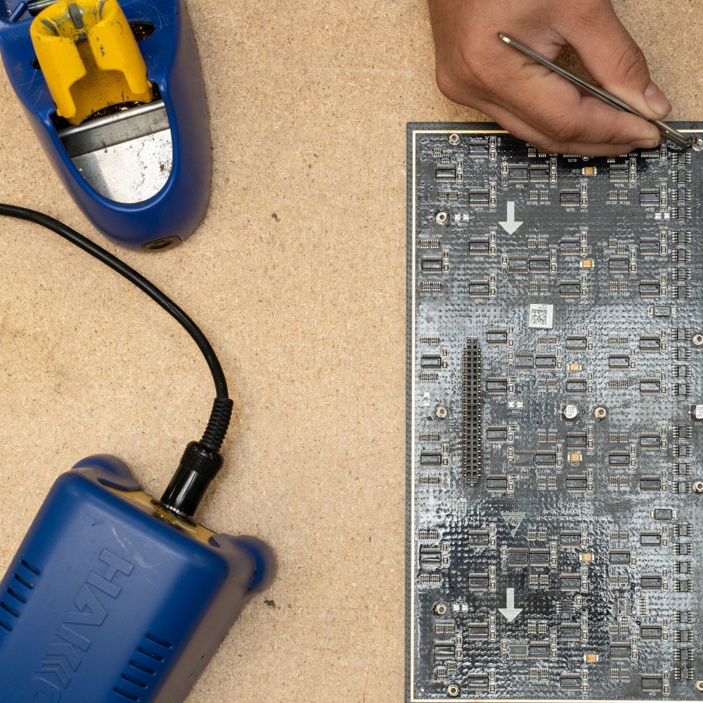 A technician works on a PCB board repair.